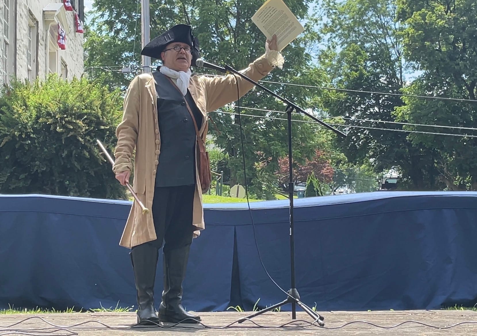 Christopher Black, as Robert Levers, takes the stage with the historic announcement.