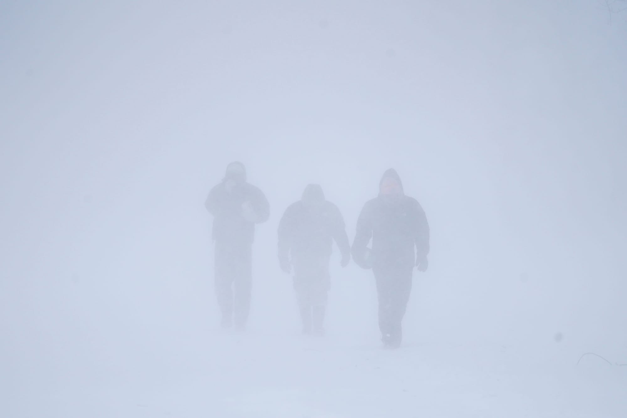 Three men walk down Richmond Avenue in whiteout conditions during a sustained blizzard in Buffalo, N.Y. on Saturday, Dec. 24,