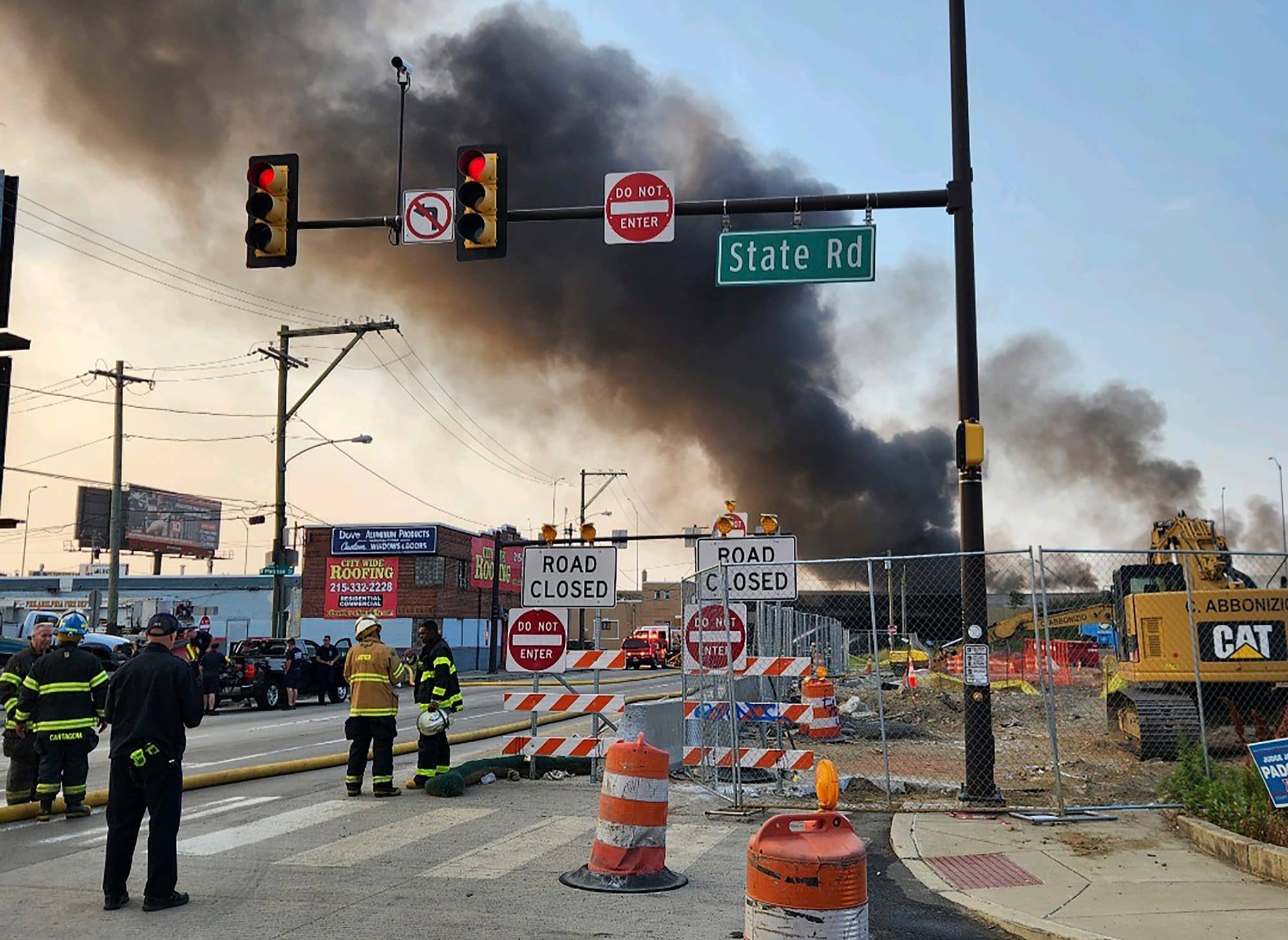 Officials work at the scene following the collapse of an elevated section of Interstate 95 after a tanker truck caught fire, 