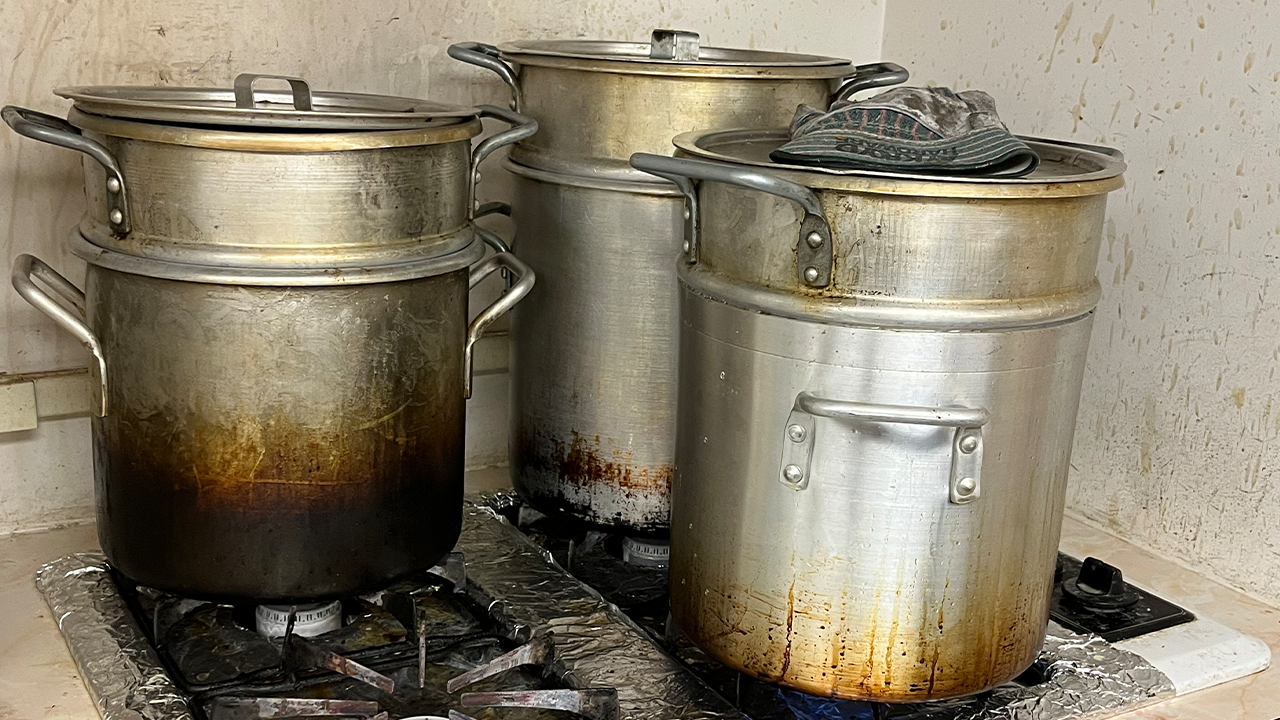 Pots of melting beeswax simmer on the stove in the candle-making space that makes up part of the basement of Central Moravian