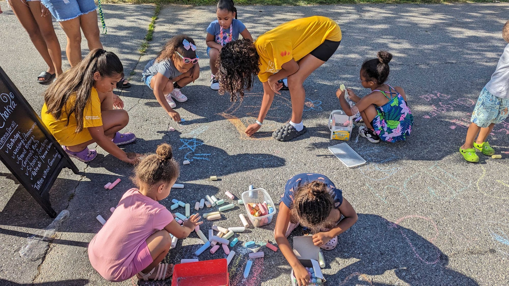 Kids draw with sidewalk chalk at National Night Out at Cedar Beach Park.