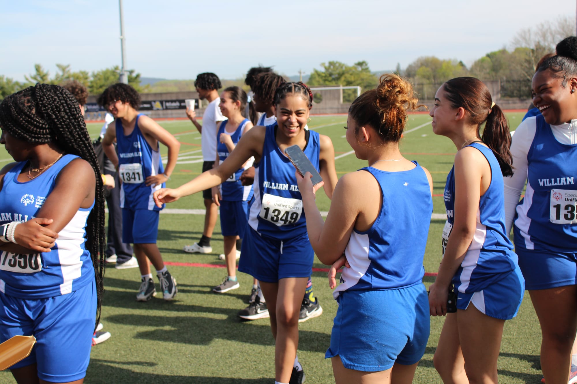 William Allen High School athletes chatting and laughing as they prepare for the relay events