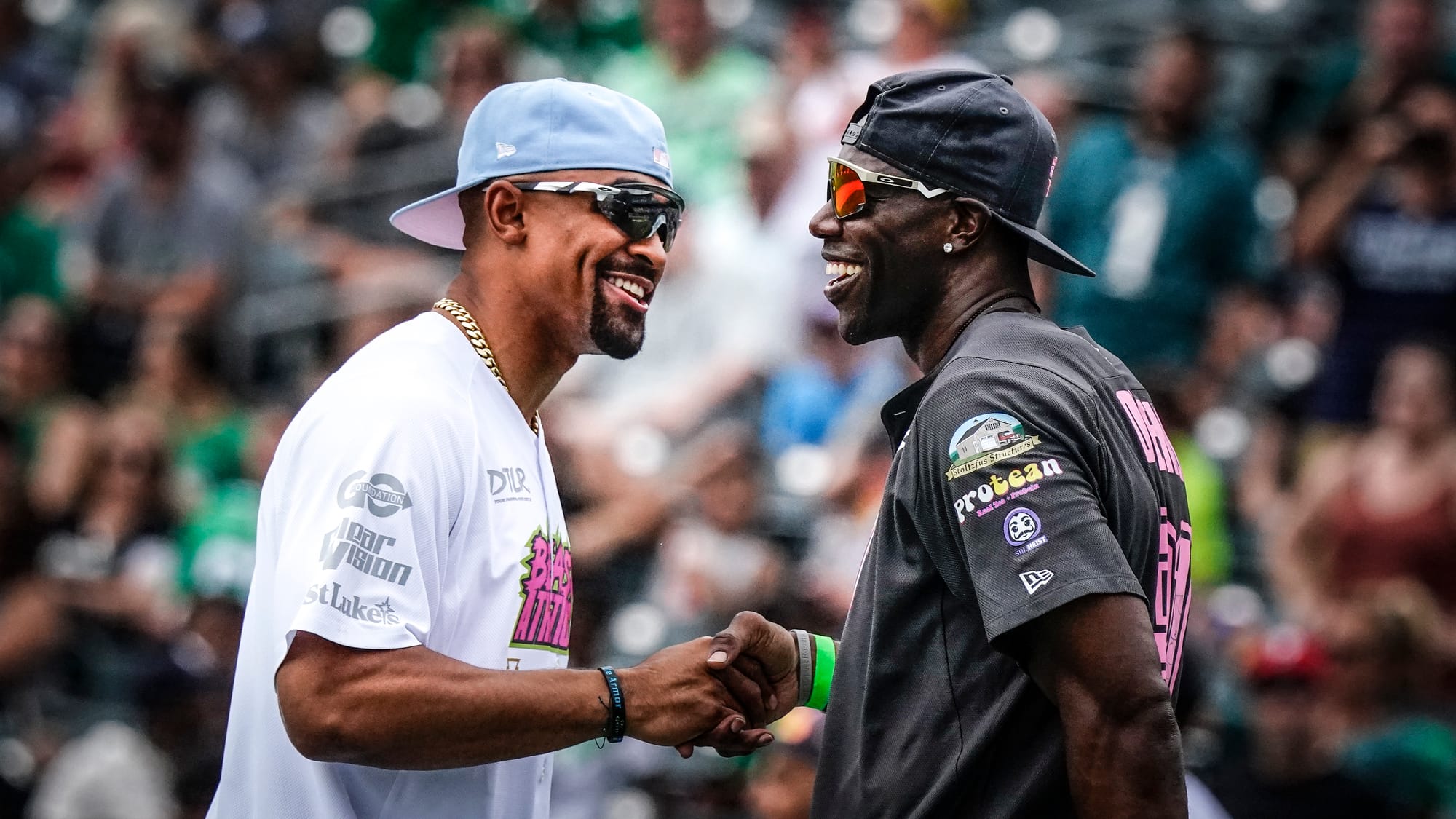 Jalen Hurts, left, greets Terrell Owens. The annual DeVonta Smith Celebrity Softball Game featuring Philadelphia Eagles and o