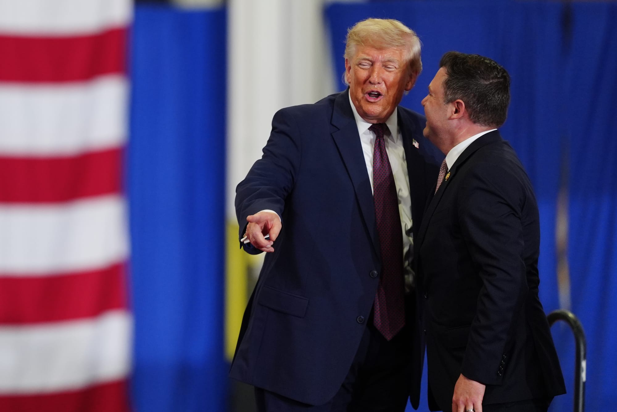 President Donald Trump and Rep. Ryan Mackenzie, R-Pa., right, appear on stage together during an event at a Mack Trucks facil