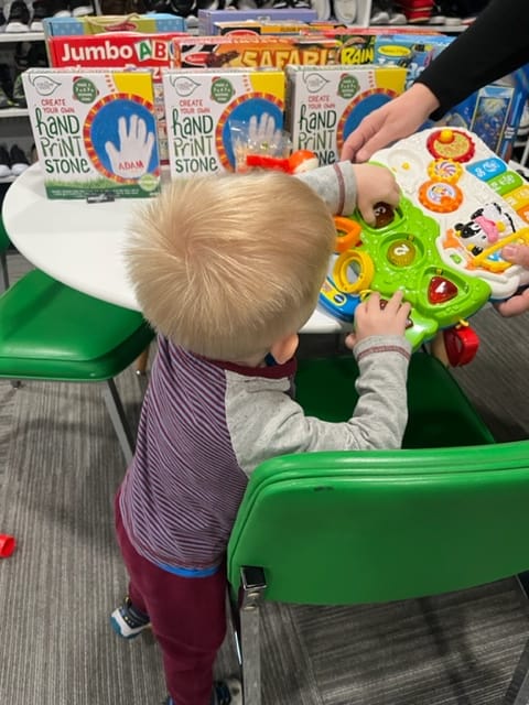A little boy in foster care looks at the toys at the Kindness Project.