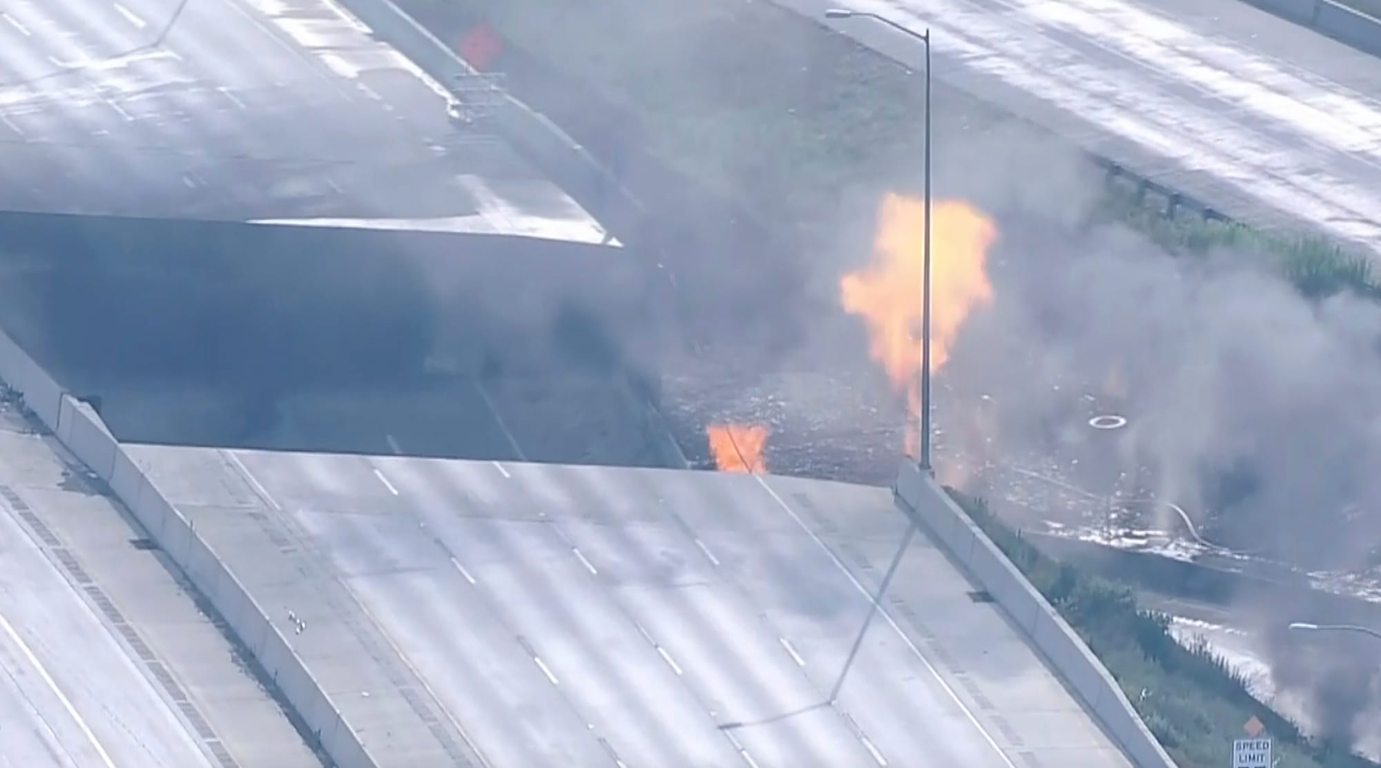 Officials work at the scene following the collapse of an elevated section of Interstate 95 after a tanker truck caught fire, 