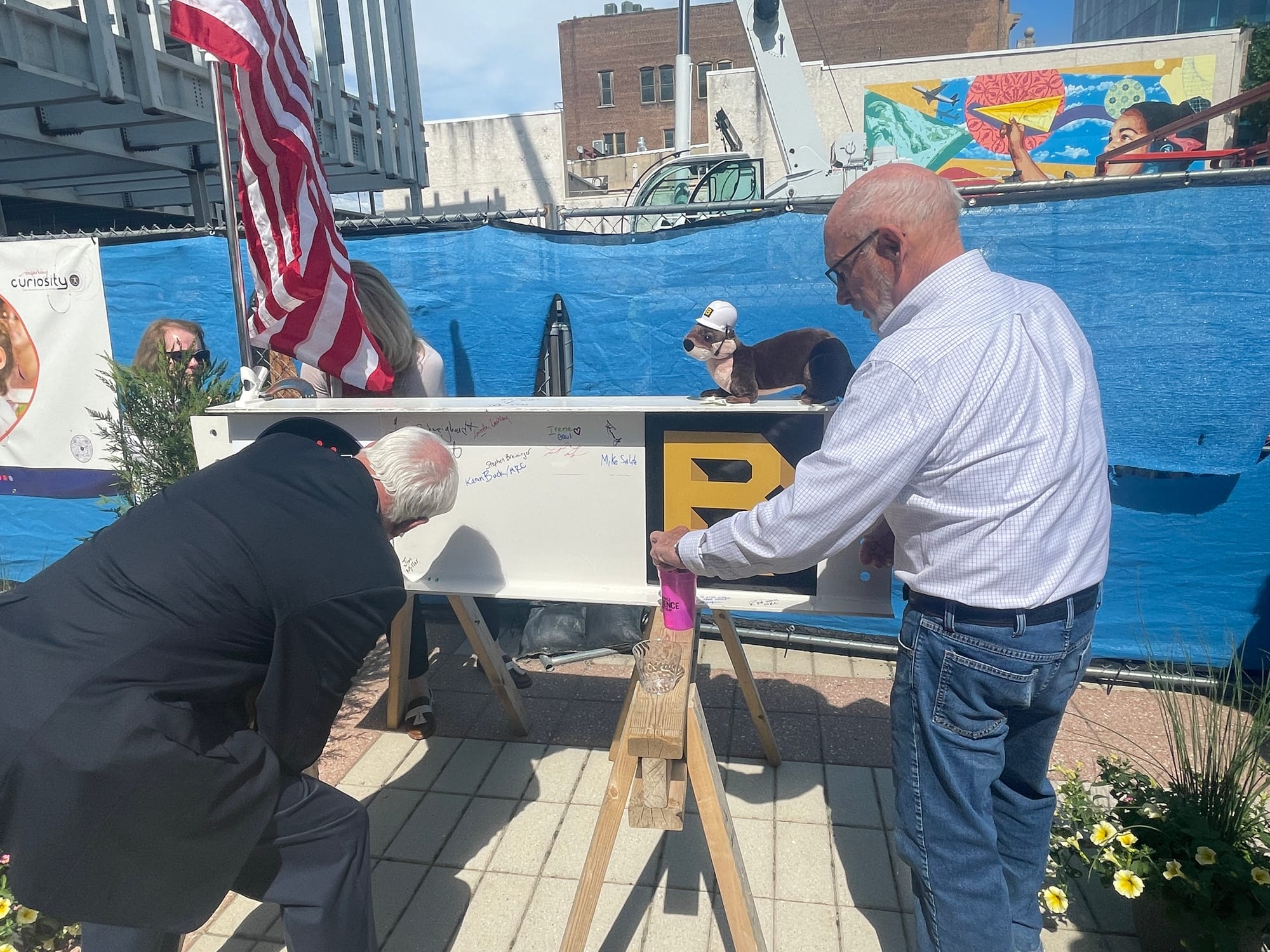 Two guests sign the final steel beam at the future site of the Da Vinci Center in Allentown.