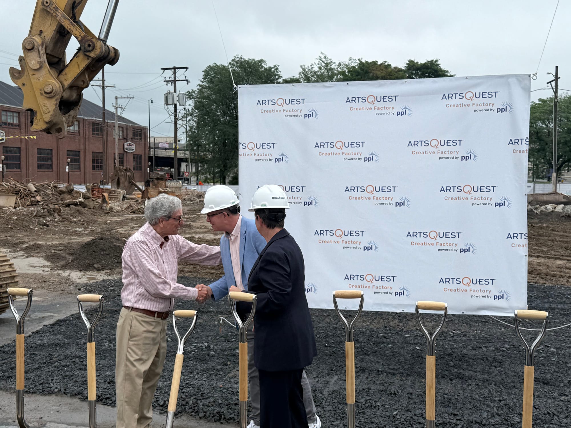 MusikFest founder Jeff Parks shakes hands with COO Curtis Mosel as ArtsQuest president Kassie Hilgert watches on. The group a