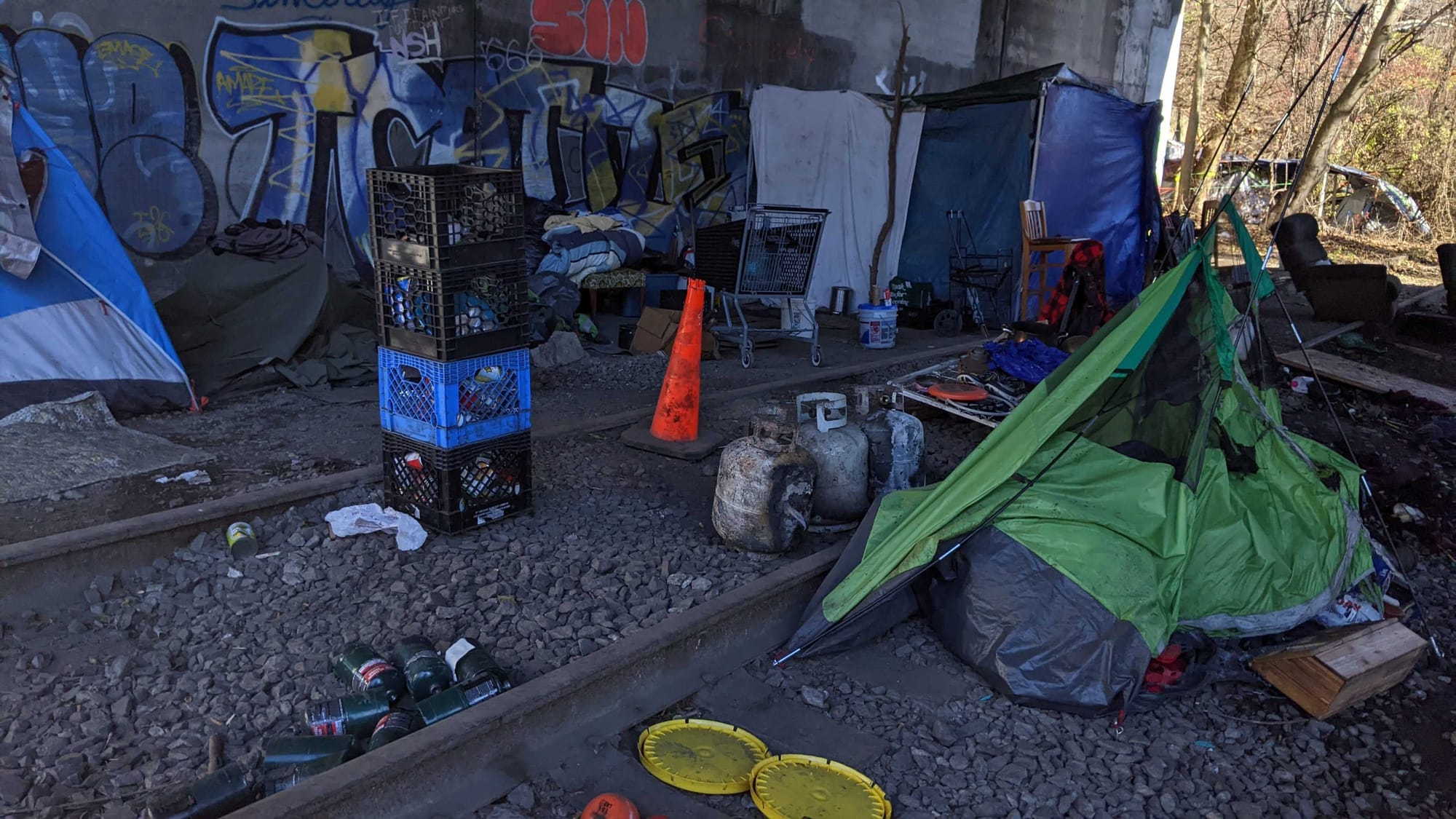 Police say two adult men were found with burns to their arms and hands following an early morning fire at an encampment under