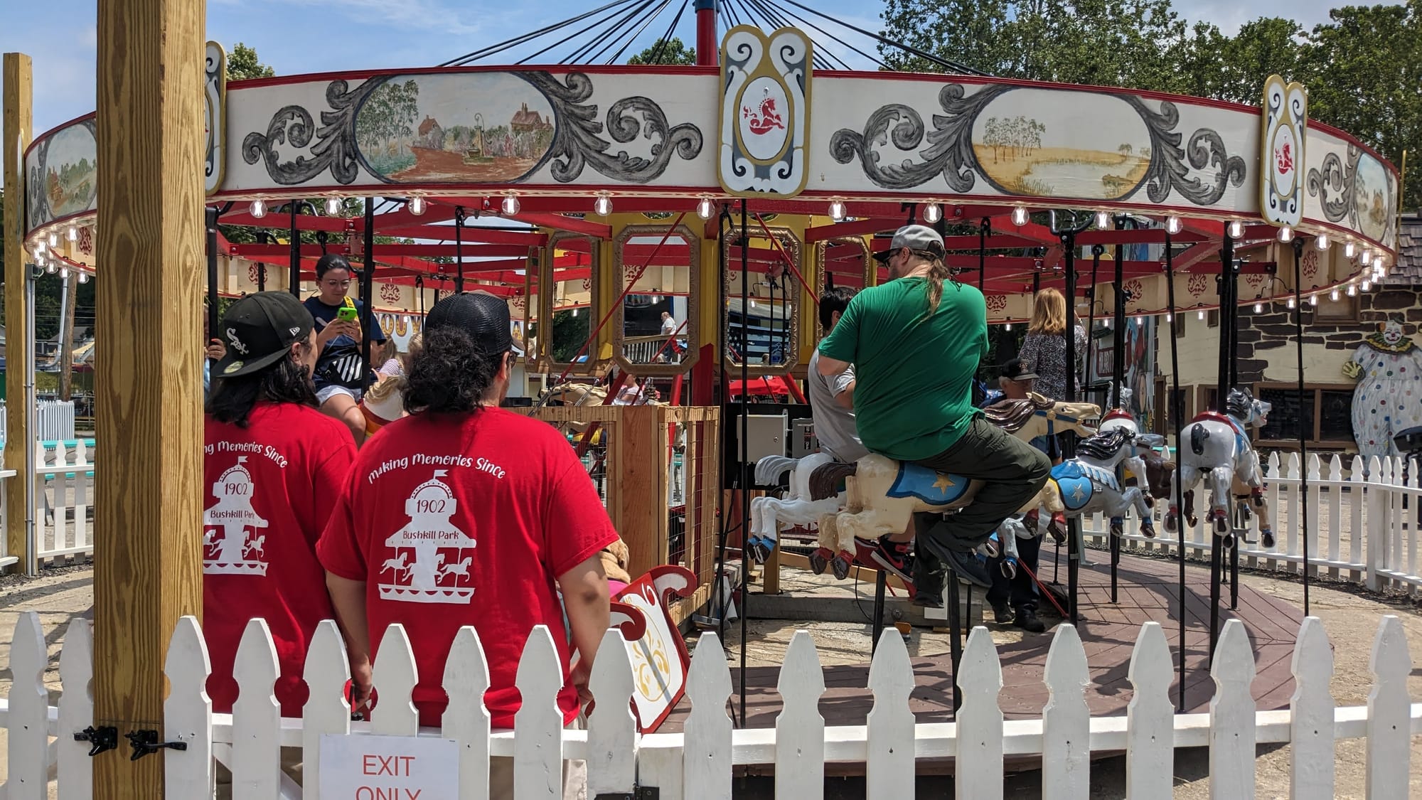 Workers watch some of the first passengers on a 1928 carousel during its opening day Sunday afternoon.