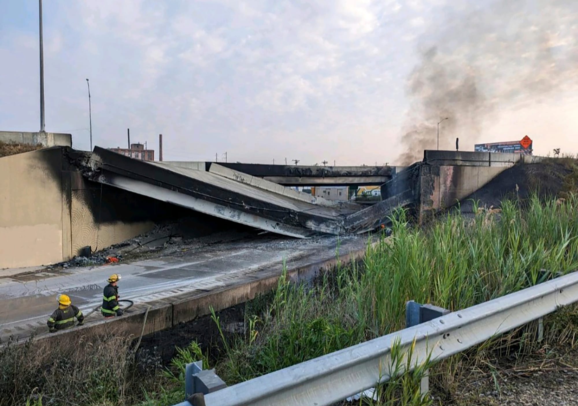 Officials work at the scene following the collapse of an elevated section of Interstate 95 after a tanker truck caught fire, 