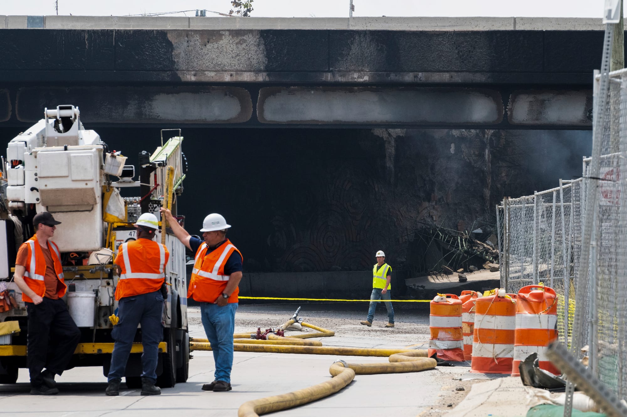 Officials work at the scene following the collapse of an elevated section of Interstate 95 after a tanker truck caught fire, 