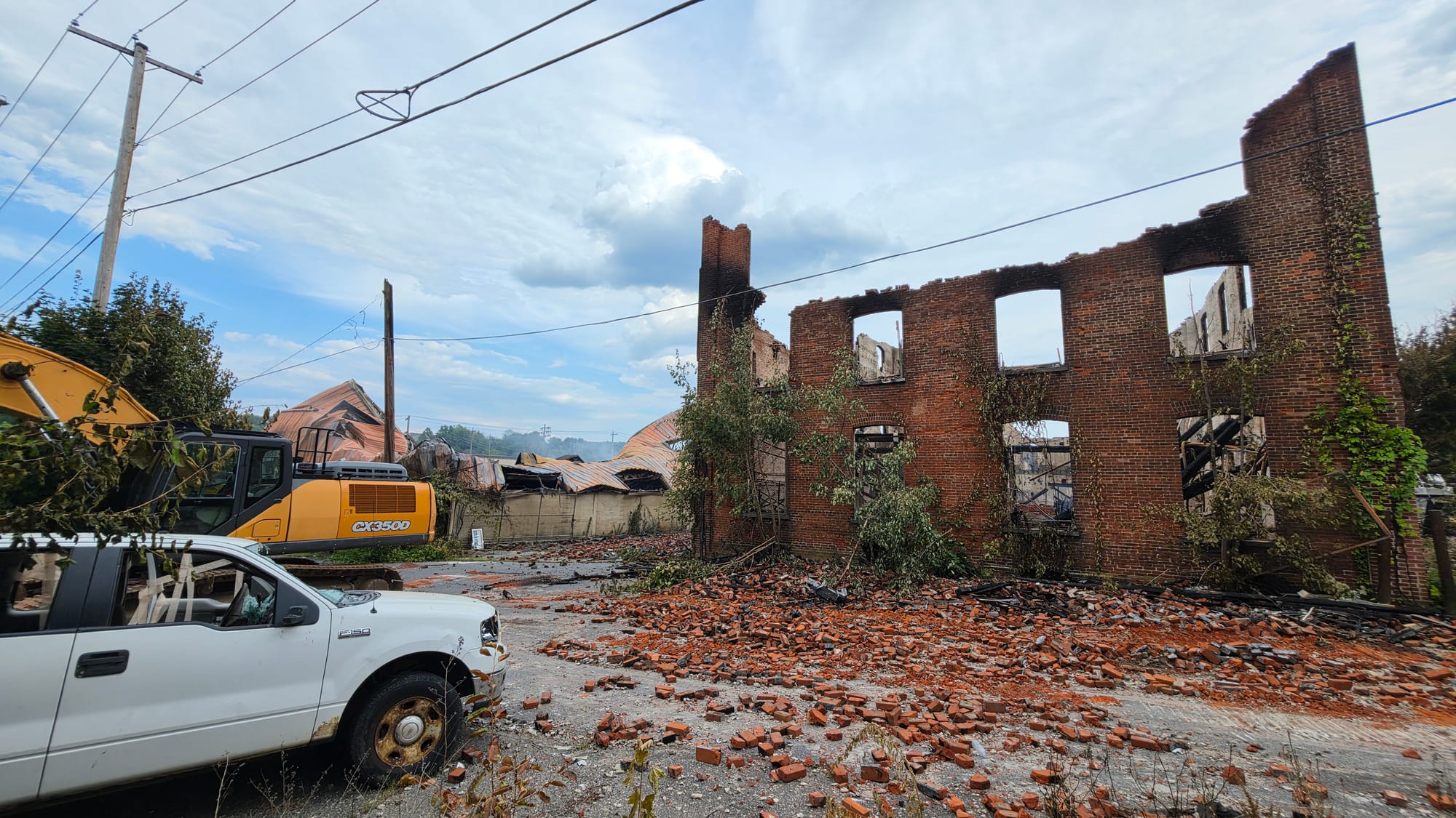 The burned out remains of the former American Atelier furniture factory on Front Street continued to smolder Thursday, June 2