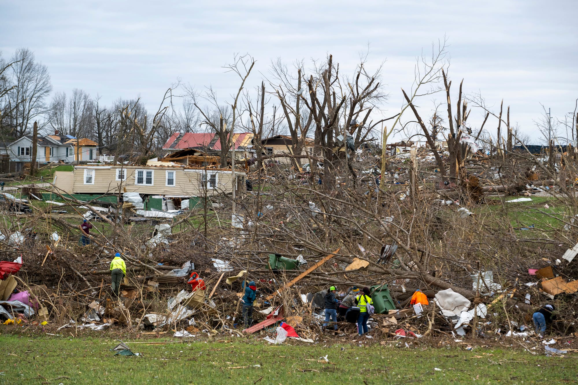 Volunteers comb through an area that was heavily damage by a tornado in Sullivan, Ind., Saturday, April 1, 2023, as search-an