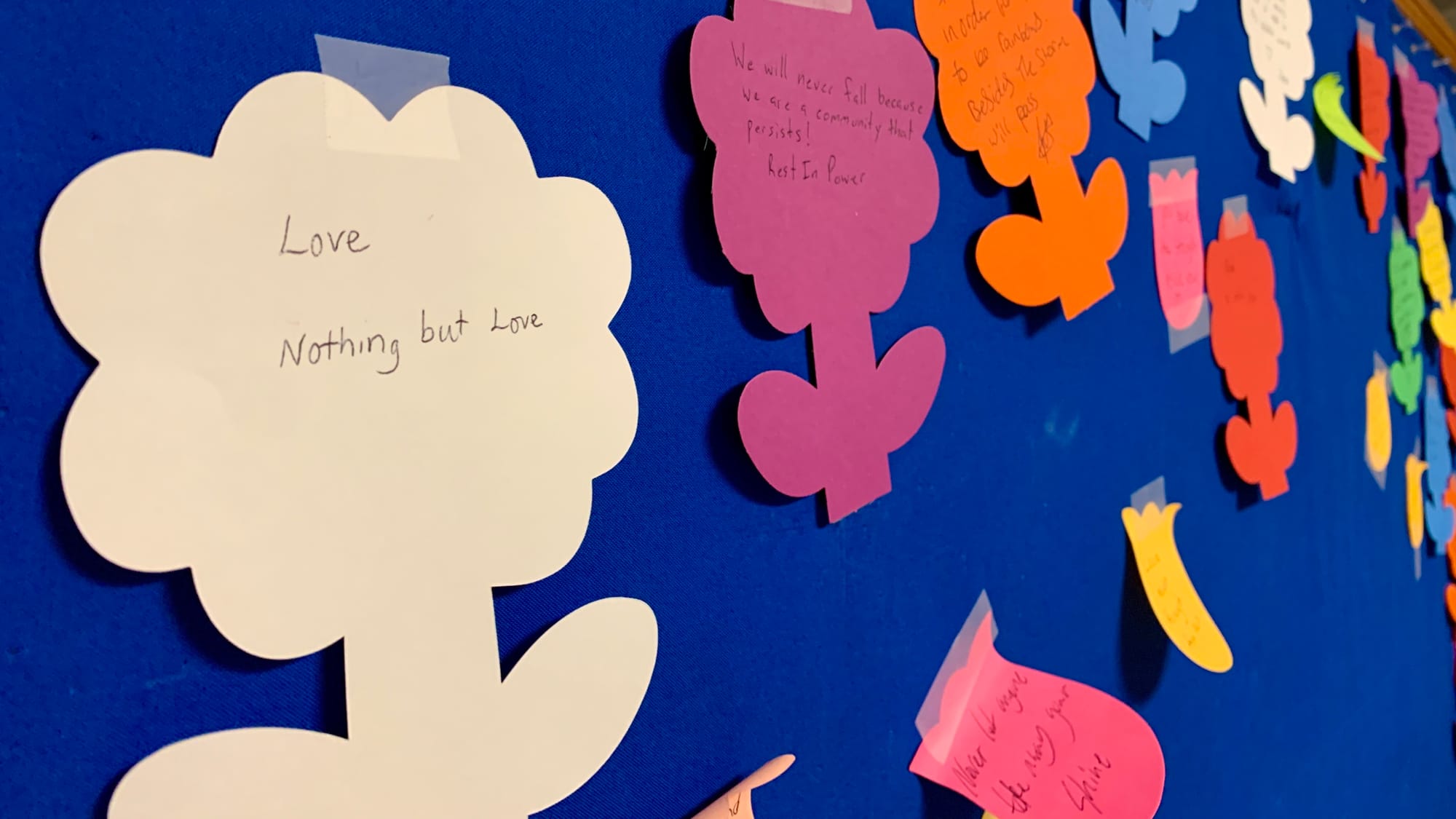 Notes written on paper flowers after the Transgender Day of Remembrance vigil.