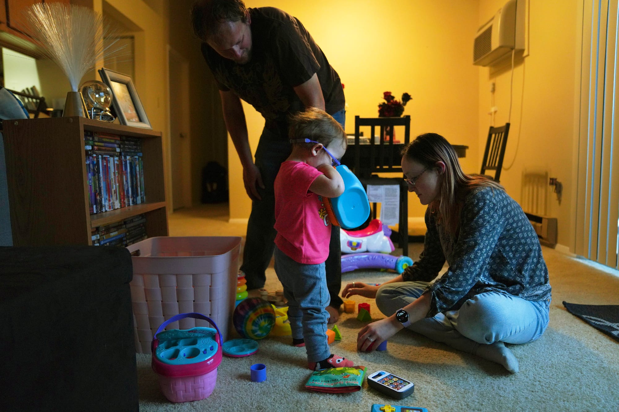 Andrew and Lauren Hackney play with their 1-year-old daughter during a supervised visit at their apartment in Oakdale, Pa., o