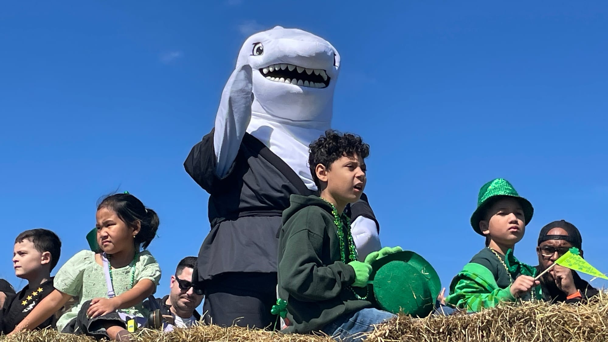 Action Karate's shark mascot waves to the crowd on the Broad Street Bridge during the Parade of Shamrocks on March 16, 2024.