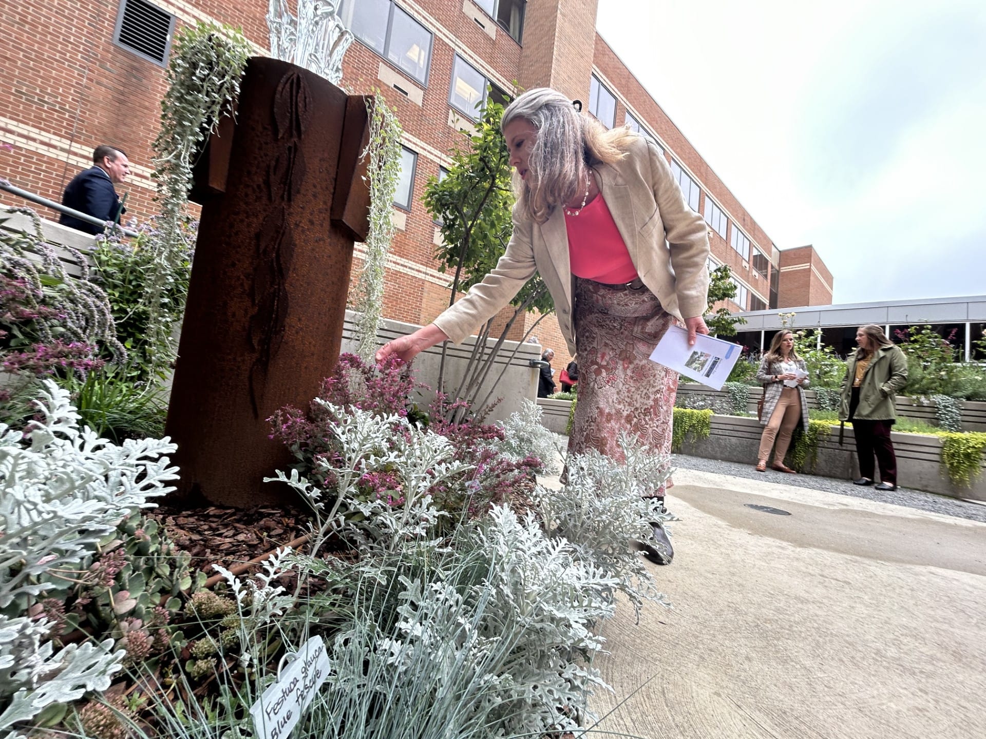 Kristen Lissy, master gardener, looks at plants in LVHN's community healing garden.