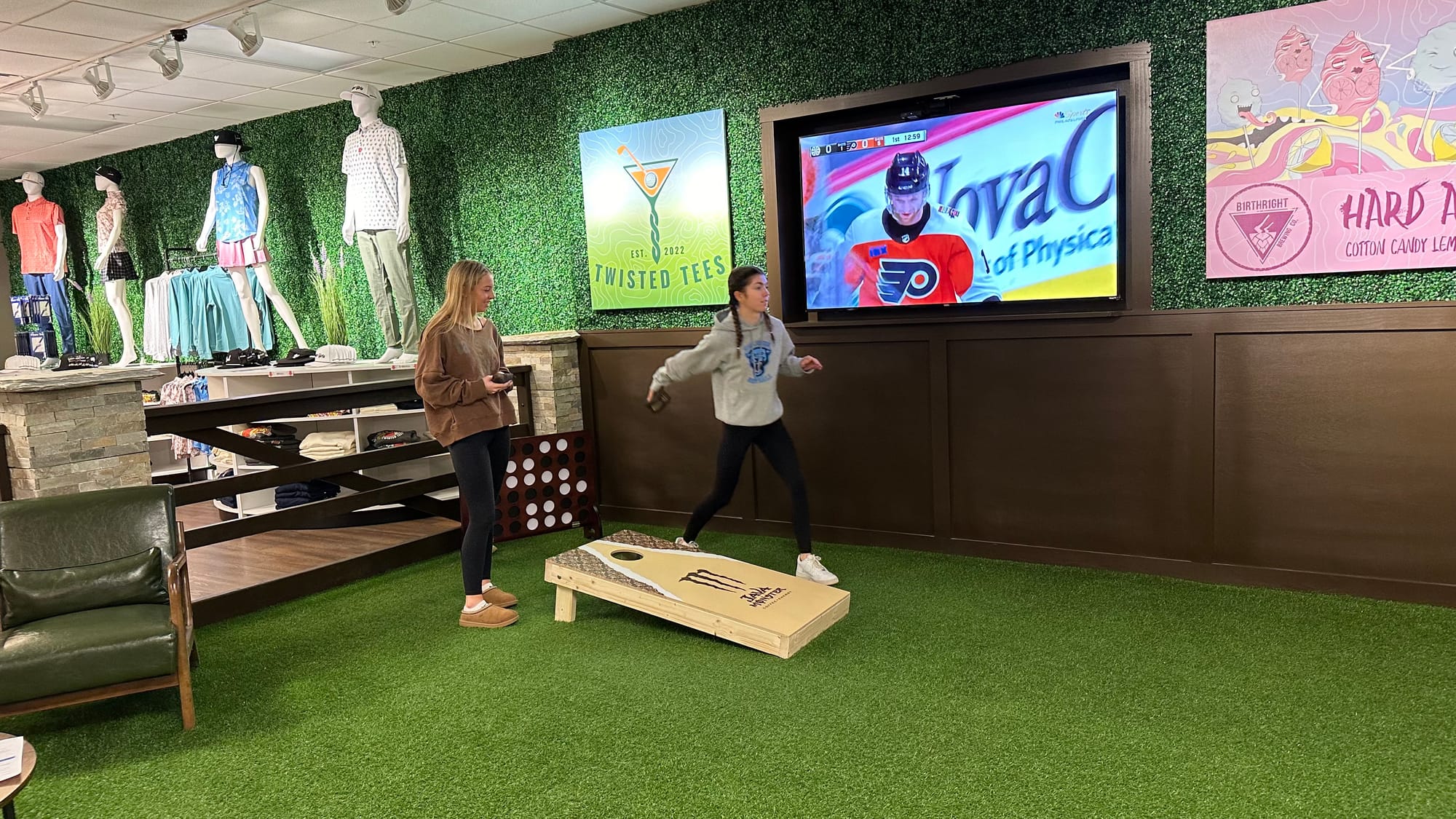 Twisted Tees co-owner A.J. Mitchell's nieces enjoy a game of corn hole at the location's grand opening on Saturday, January 2