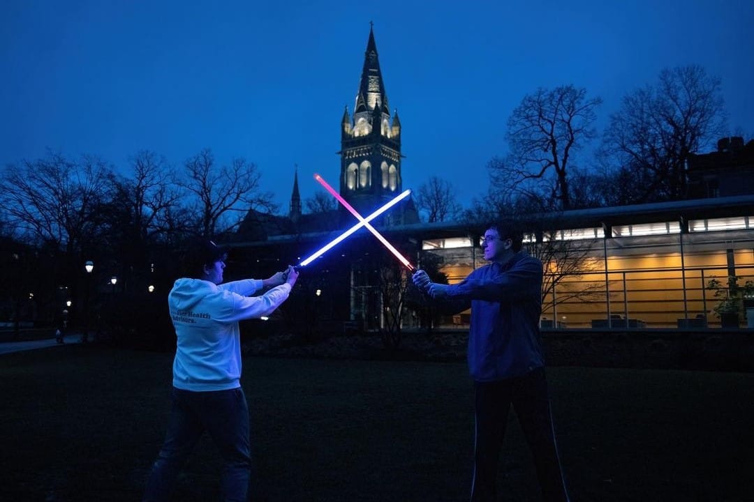 Members of the Lehigh Lightsaber Club dueling at nighttime on campus