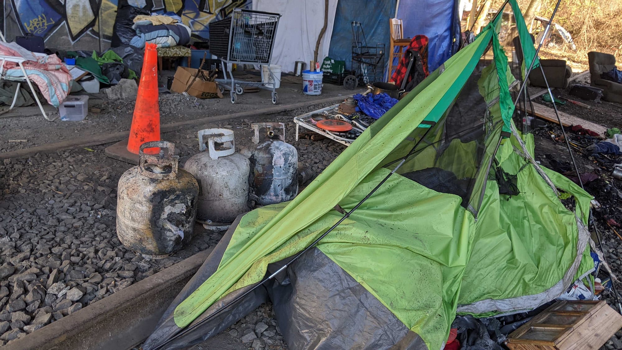 Police say two adult men were found with burns to their arms and hands following an early morning fire at an encampment under
