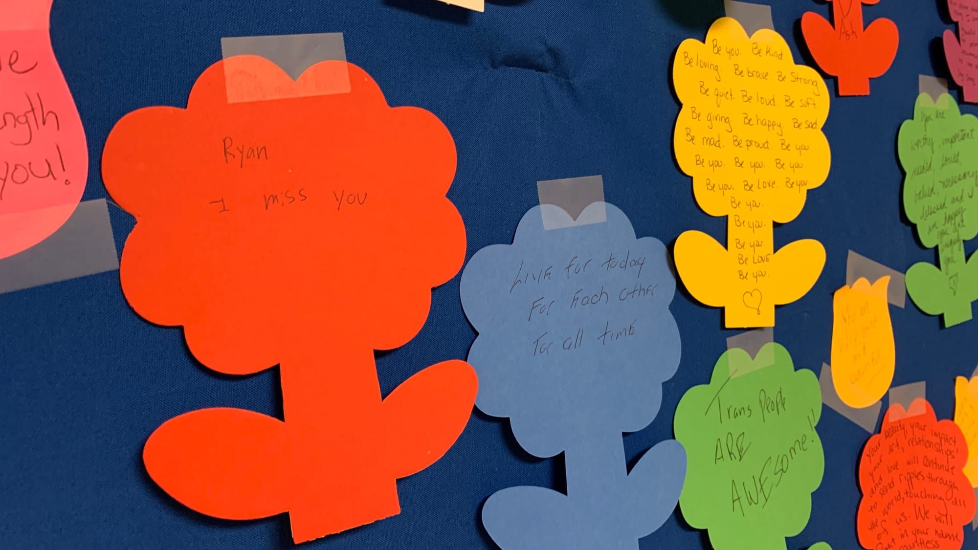 Notes written on paper flowers at the Transgender Day of Remembrance vigil.