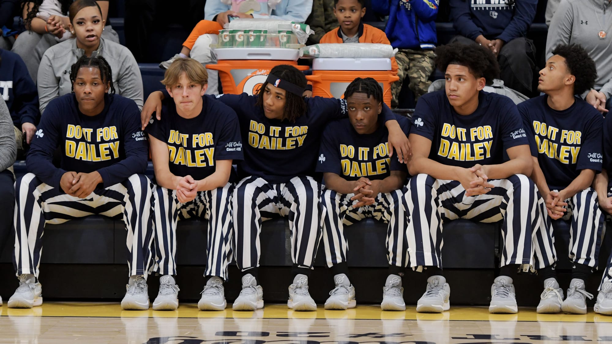Players sit on thier bench before a court dedication for Jeff Dailey on Friday, December 1, 2023, at Notre Dame-Green Pond Hi