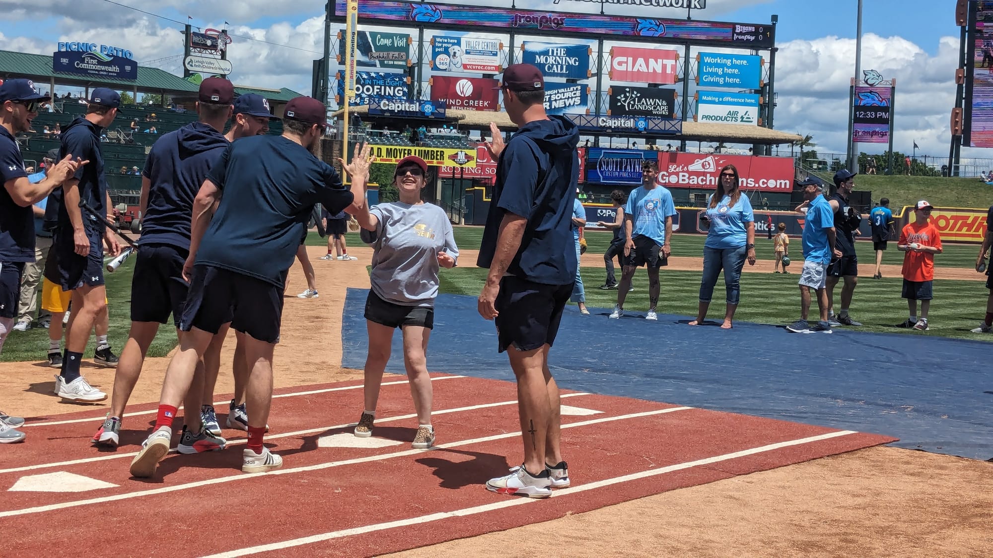 A Miracle League player celebrates at home plate with members of the Lehigh Valley IronPigs during an exhibition game between