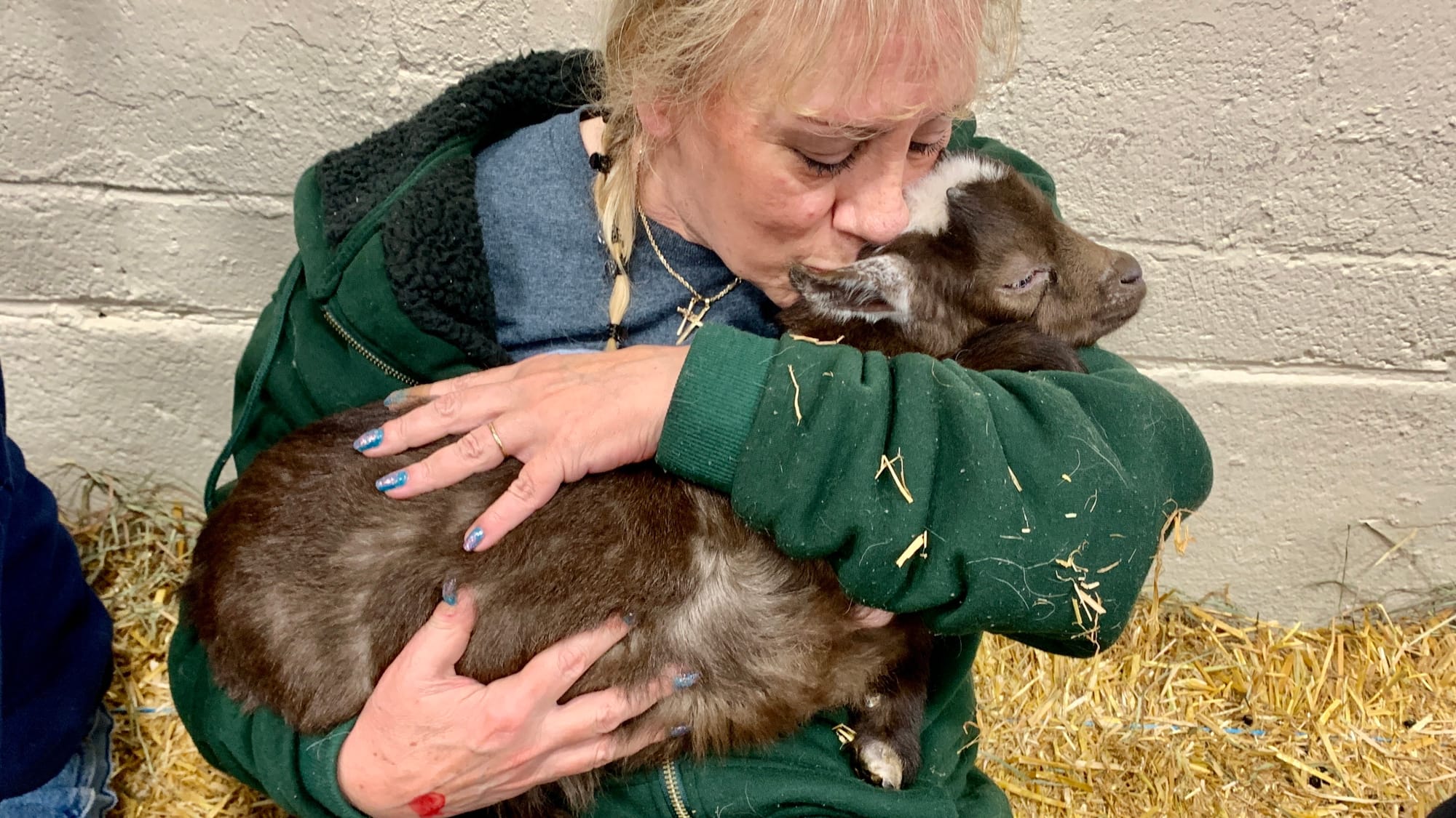 Attendee Lori Curry snuggles a goat at the Steinmetz Family Farm's Baby Goat Snuggling.