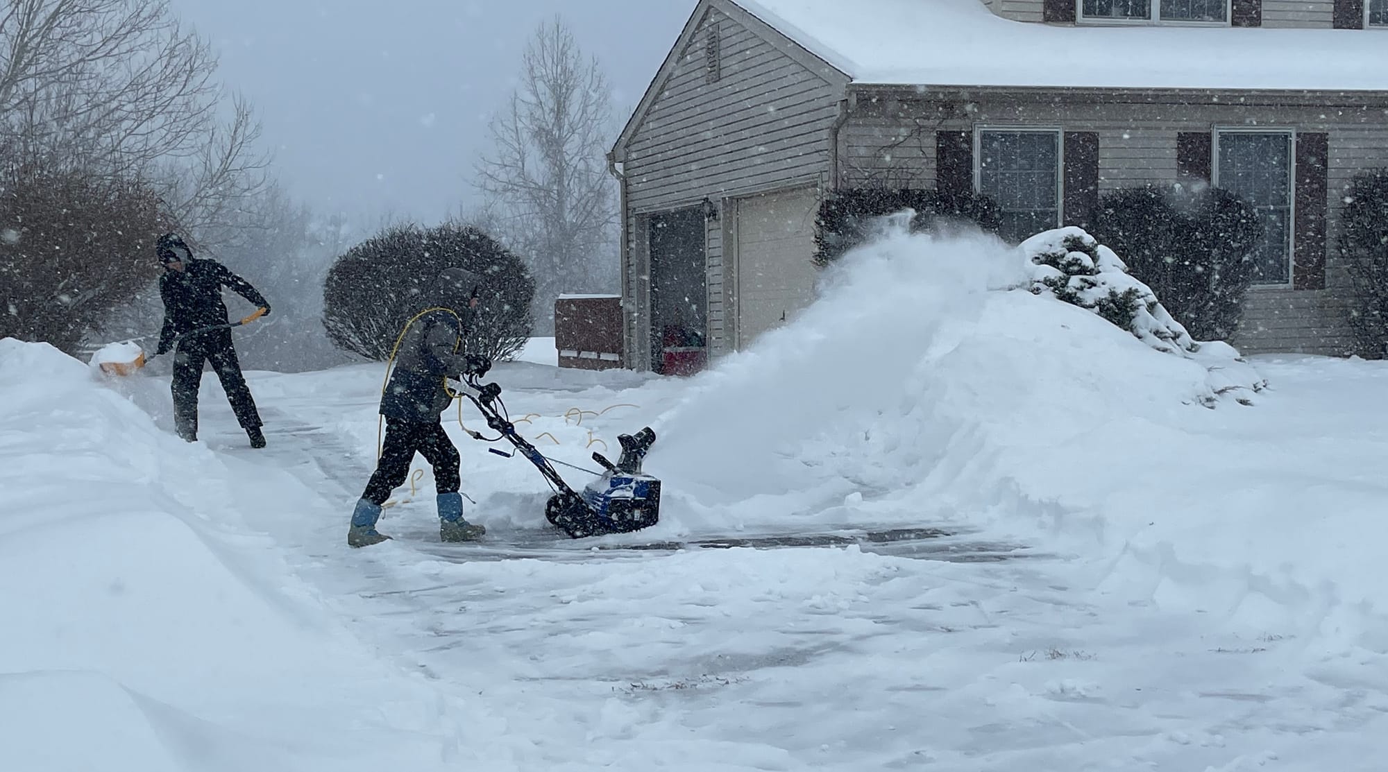 Residents clear snow from a driveway along Grandview Avenue in Palmer Township as a winter storm sweeps across the region on 
