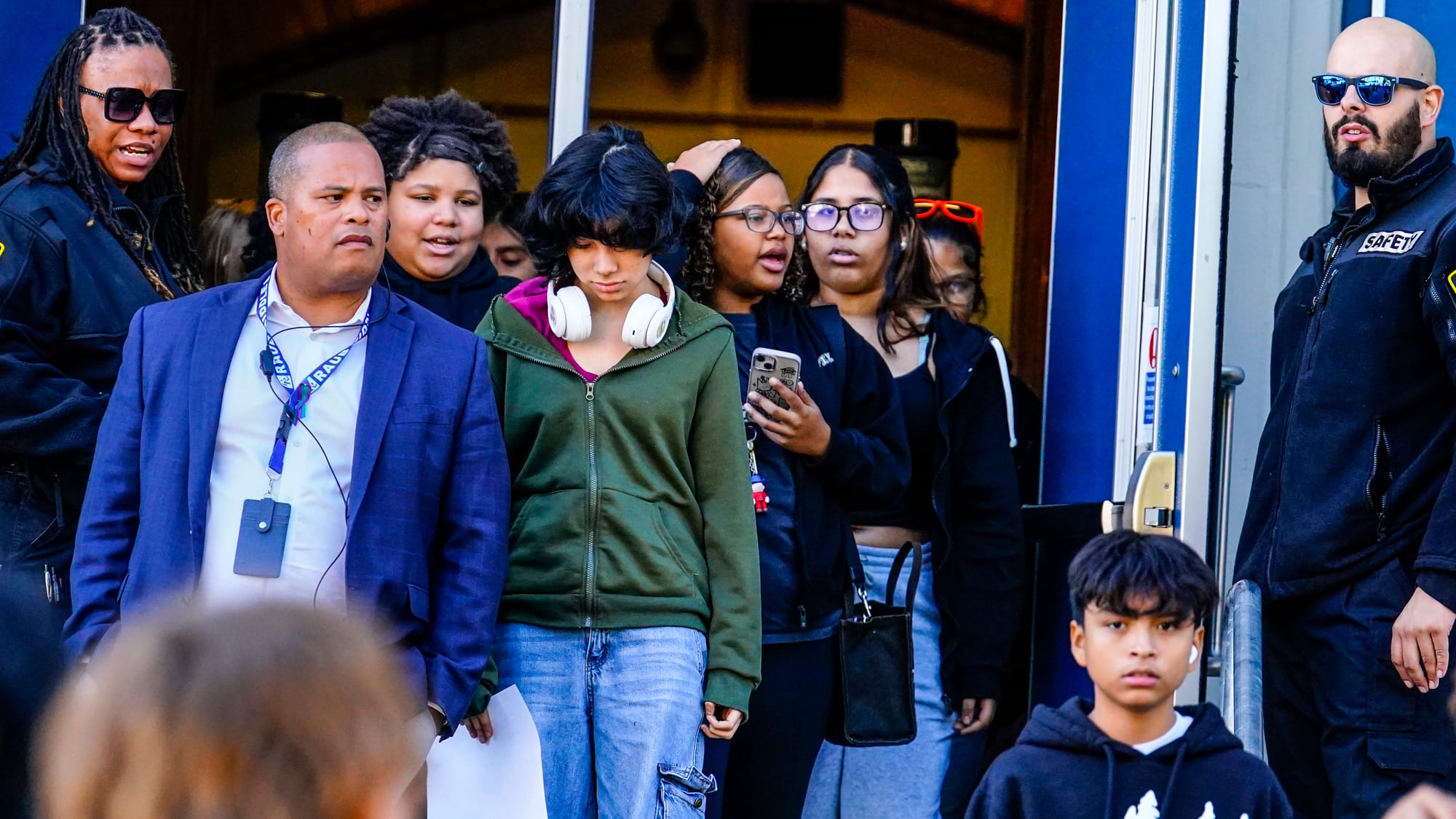 Principal José Delgado, left, watches students head home from Raub Middle School in Allentown, Pa. on Thursday, October 17, 2