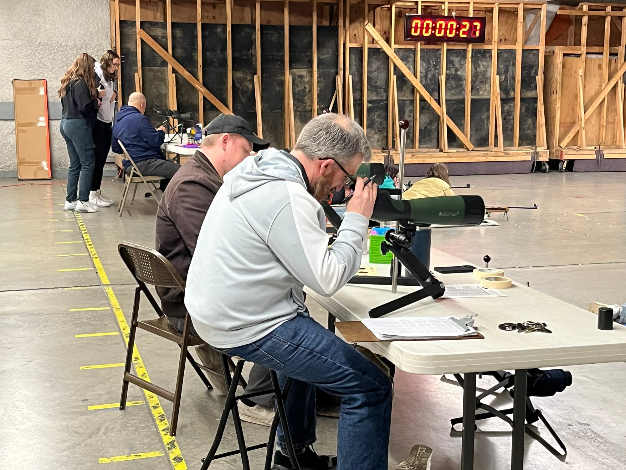 Southern Lehigh head coach Rob Gaugler, foreground, looks down range at the targets being shot by Kayla Trinkle and Sierra Gi