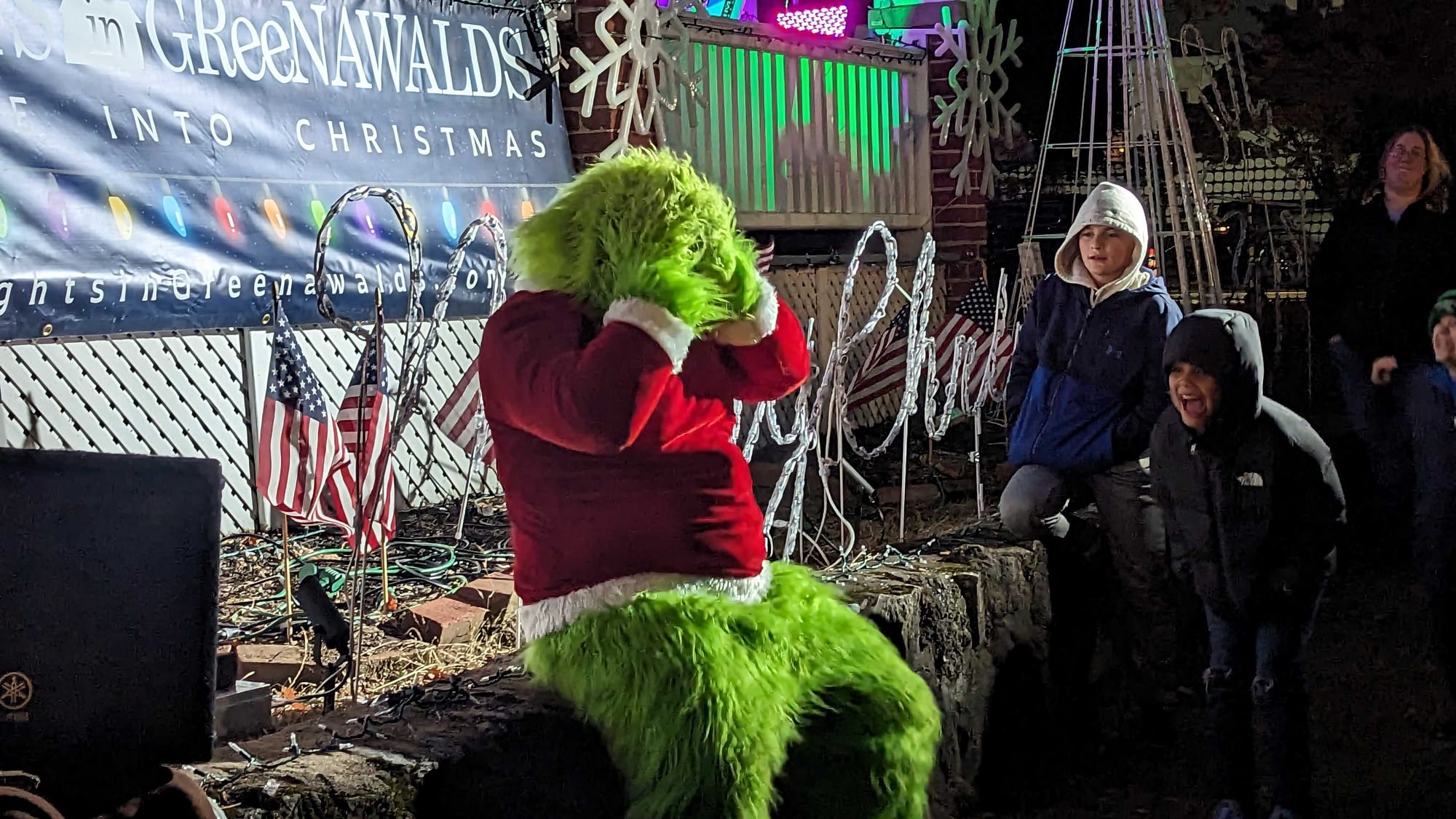 The Grinch reacts as Santa is introduced at the Lights in Greenwalds during Opening Night on Saturday, Nov. 11, 2023.