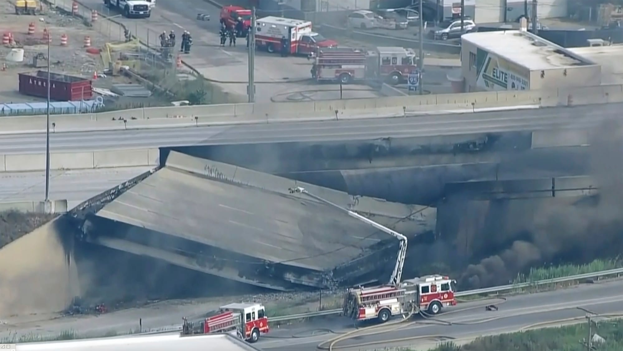 Officials work at the scene following the collapse of an elevated section of Interstate 95 after a tanker truck caught fire, 