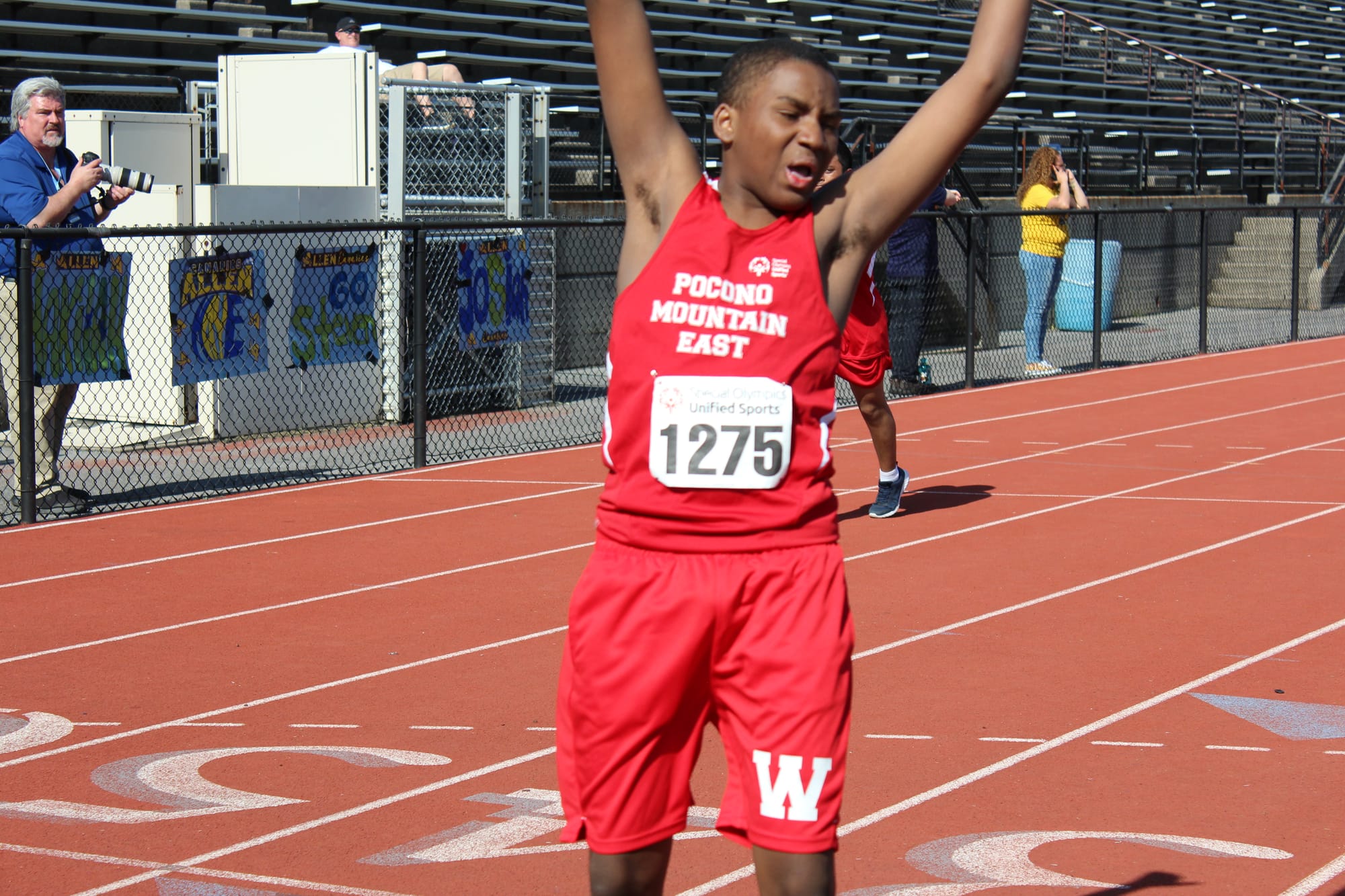 A Pocono Mountain High School student cheering after completing his 100 meter dash race during Friday's meet