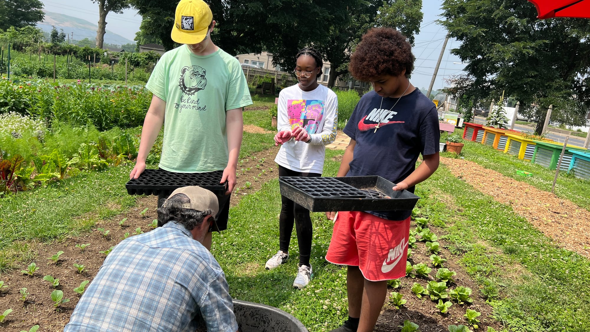 Reid shows Ralph, Layla and Elijah how to properly pack in dirt.