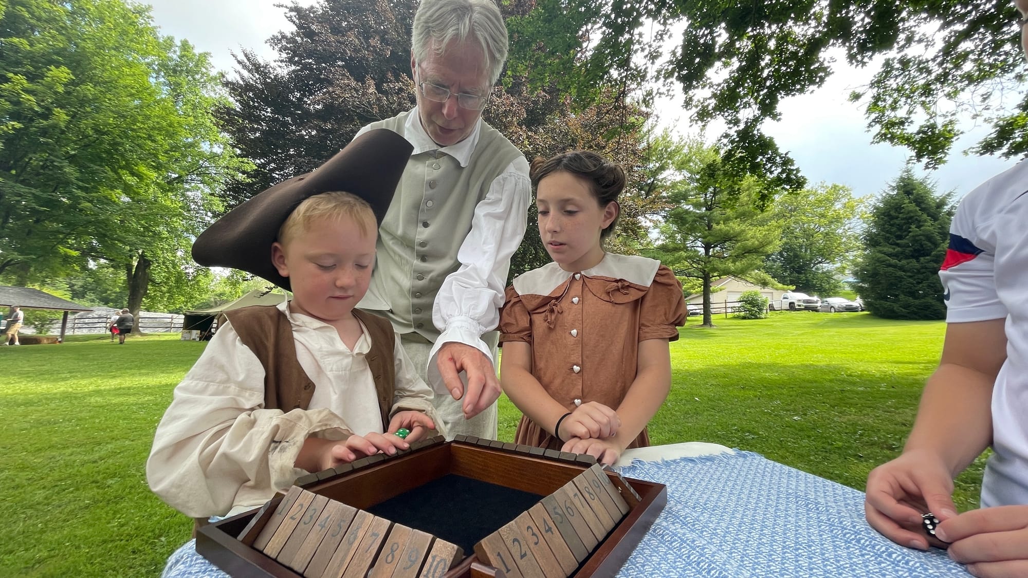 Doug Burton shows Roark and Emersyn Goldberg how to play Shut the Box.