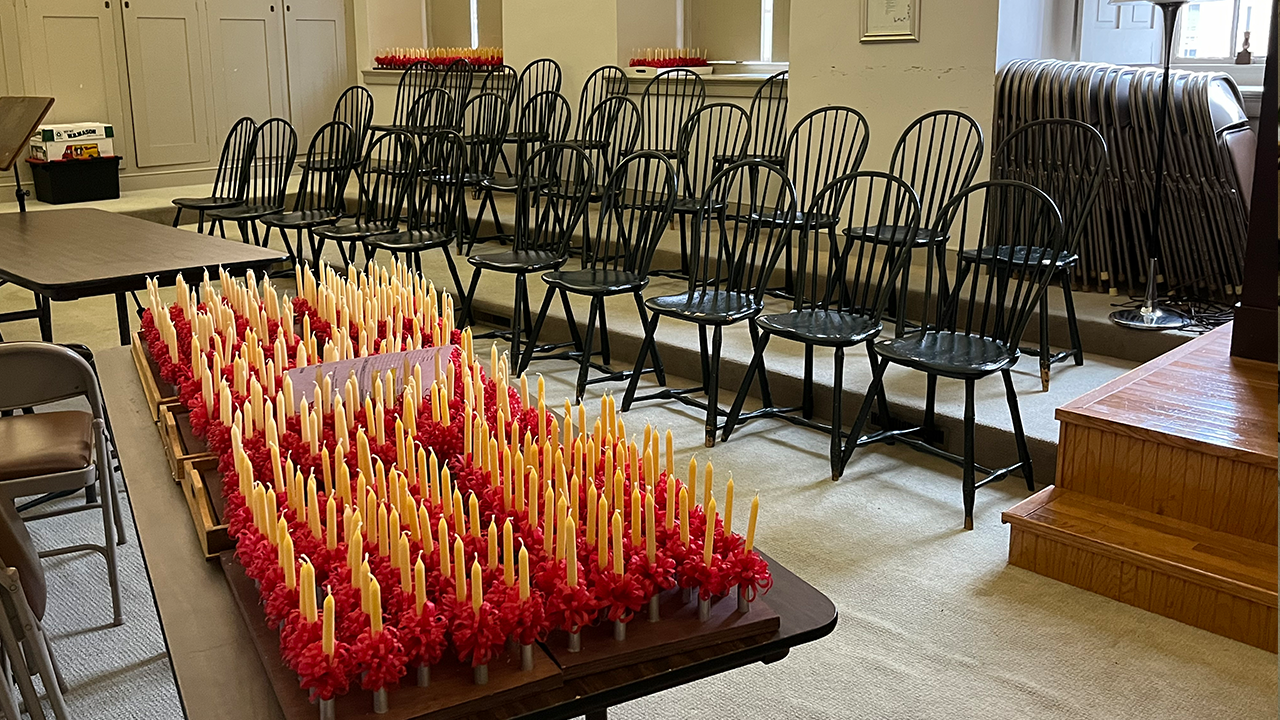 Holiday orders of 6-inch yellow beeswax candles ready for delivery line the Kleiner Saal (meeting room) at Central Moravian C