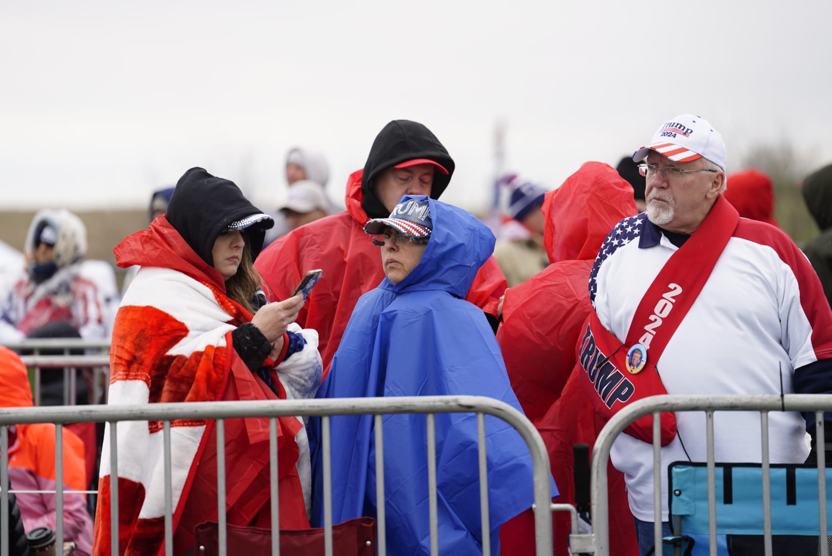 Dressed for the forecast of wind and rain Saturday, Trump supporters line up early in the day.