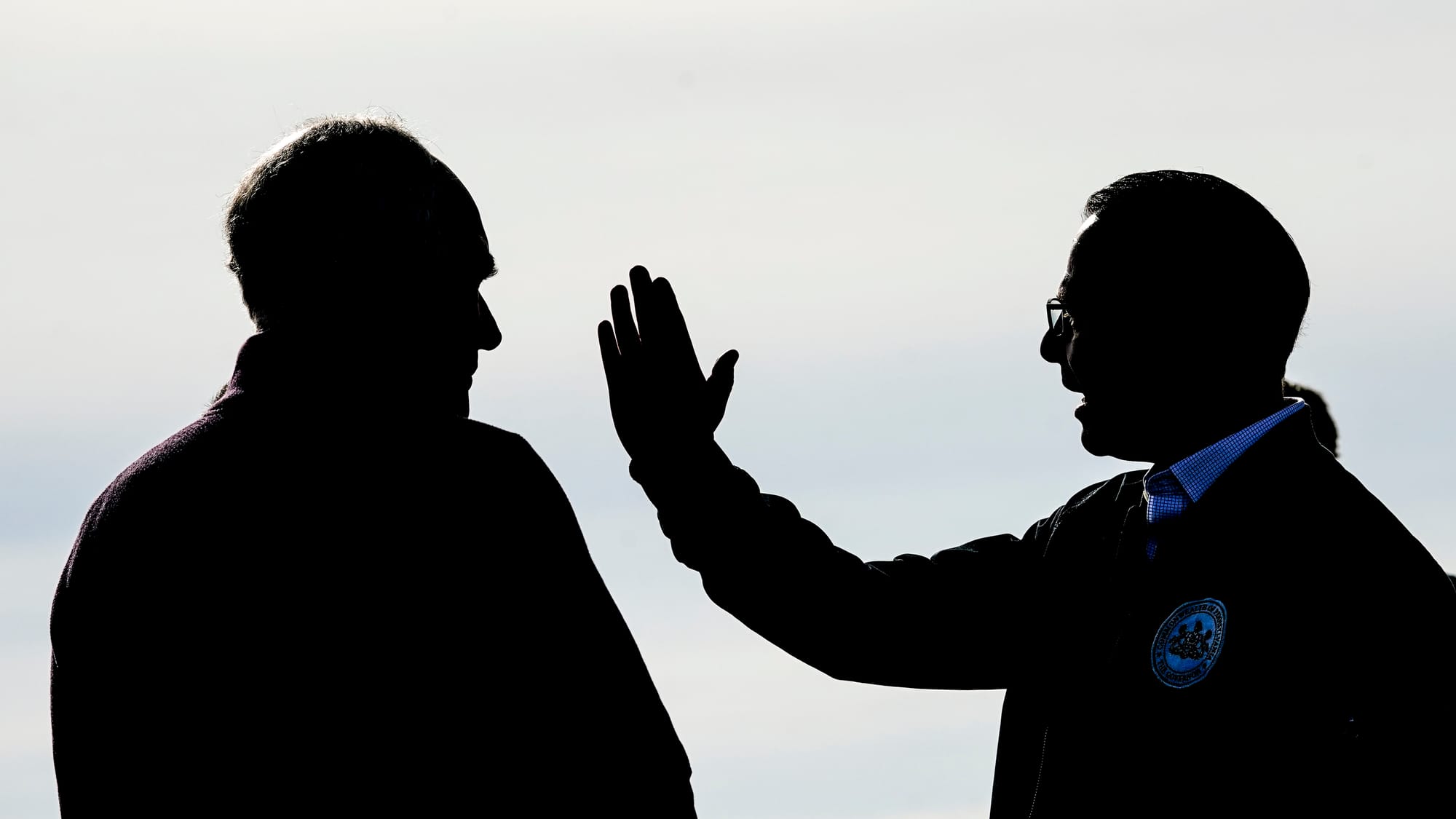 Pa. Sen. Bob Casey, left, and Pa. Gov. Josh Shapiro speak on the tarmac while awaiting President Biden. President Joseph Bide