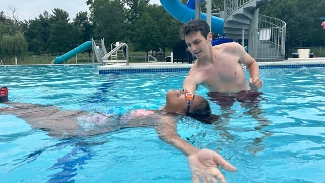 A lifeguard helps a 12-year-old girl float at Cedar Beach pool during the World's Largest Swim Lesson.