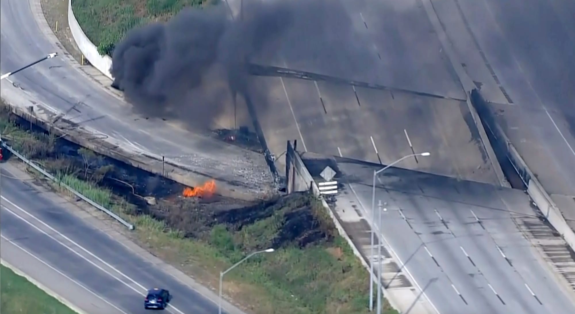 Officials work at the scene following the collapse of an elevated section of Interstate 95 after a tanker truck caught fire, 