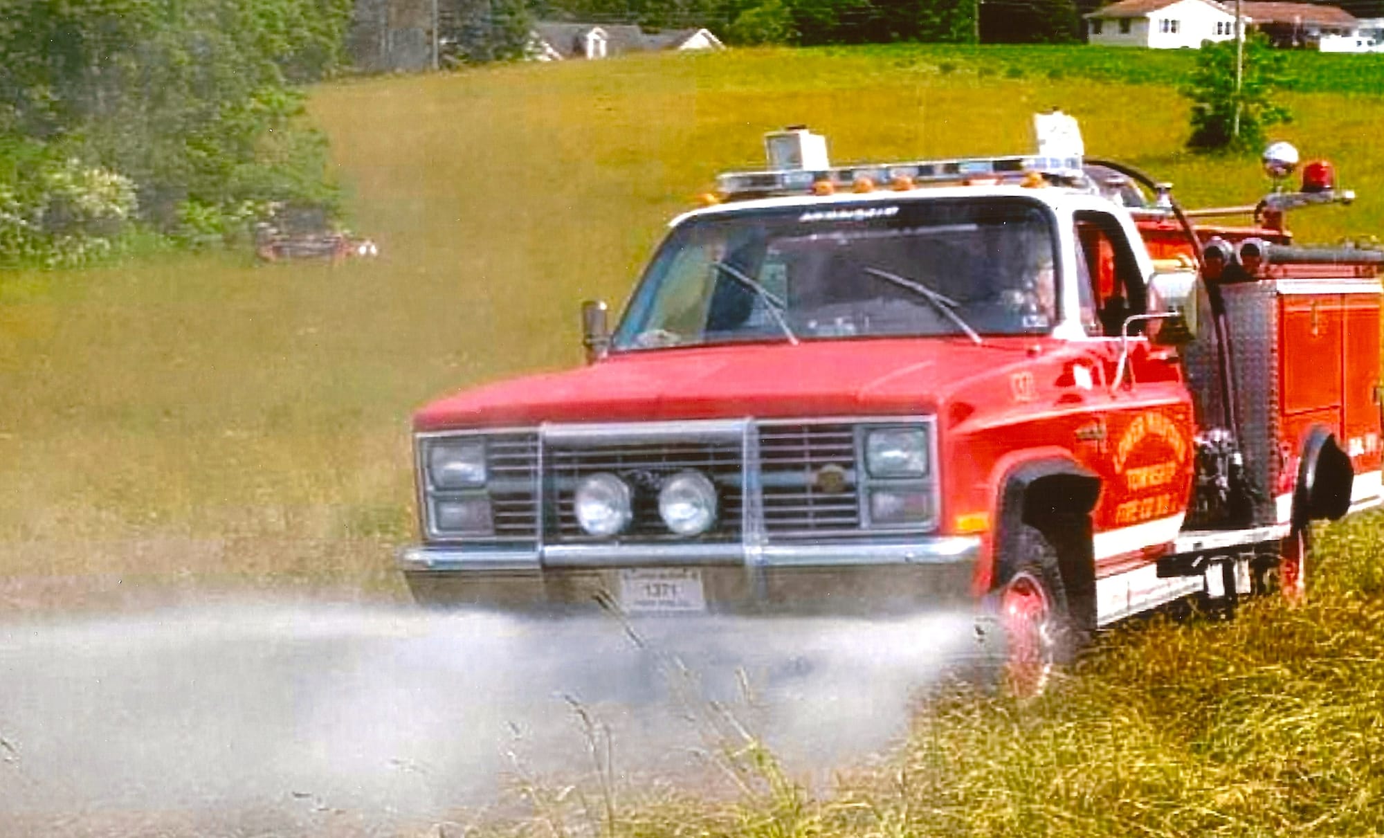 Lower Milford firefighters use the ground sweep feature on the Pierce firetruck to douse a field fire in 2020.