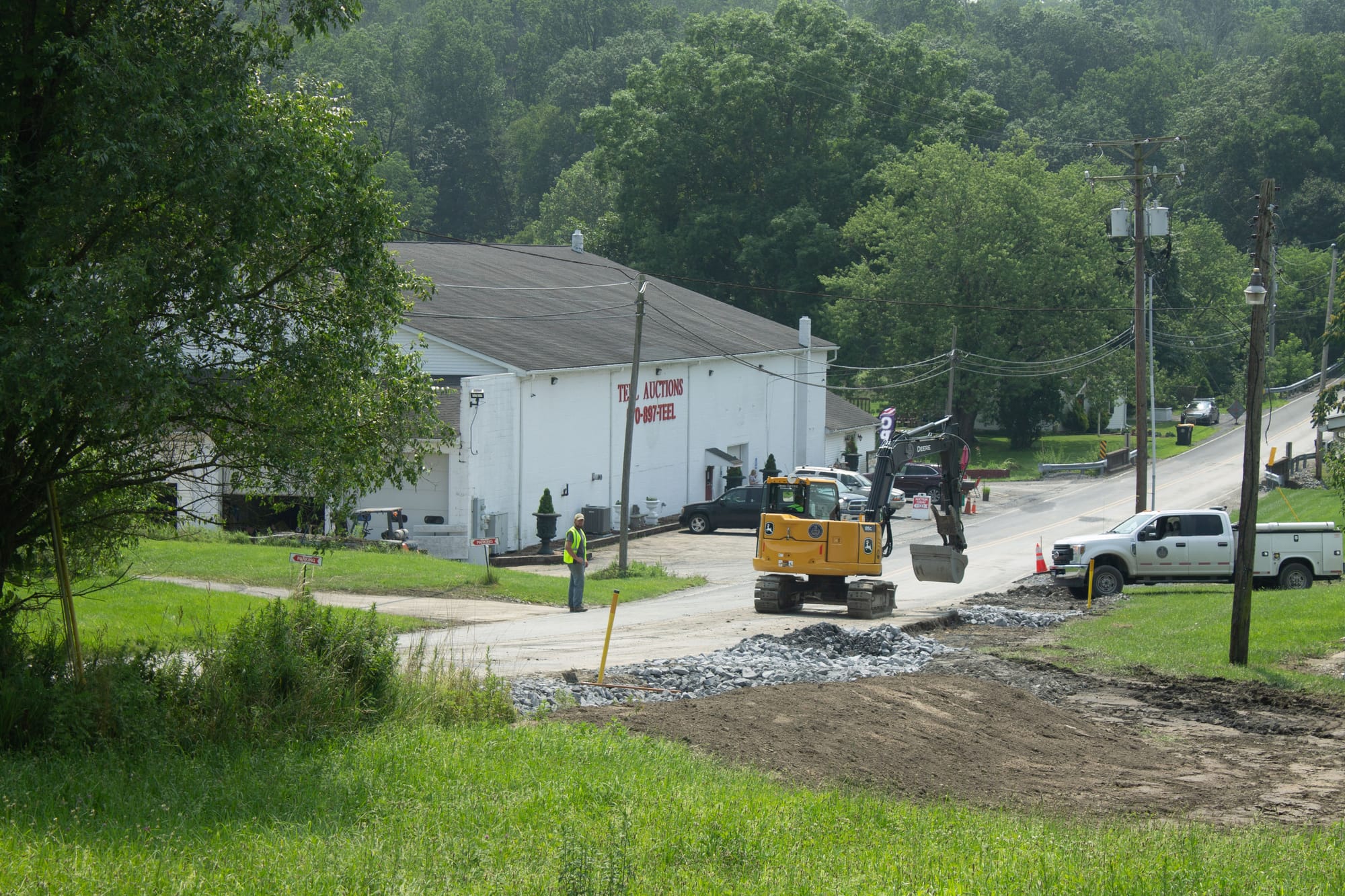 Township workers repair the damage to the roads near the local auction house. During flooding, much of this area was complete