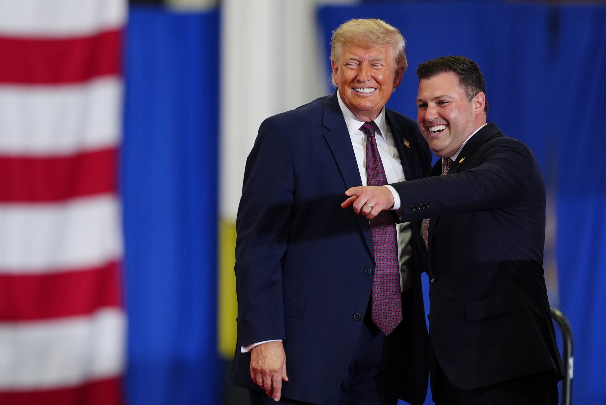 President Donald Trump and Rep. Ryan Mackenzie, R-Pa., right, appear on stage together during an event at a Mack Trucks facil