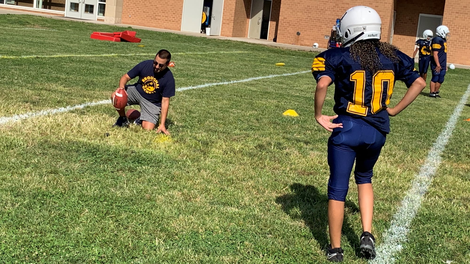 Sairett Rosario and Assistant Coach Charles Falteich work on kicking