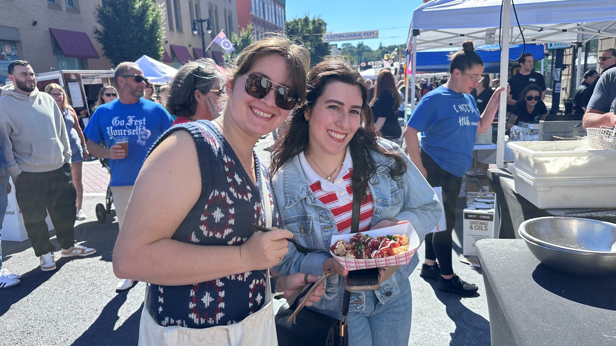 Emma Gargiulo and Anastasia Bonifate try some garlic calamari from 3rd and Ferry Fish Market.