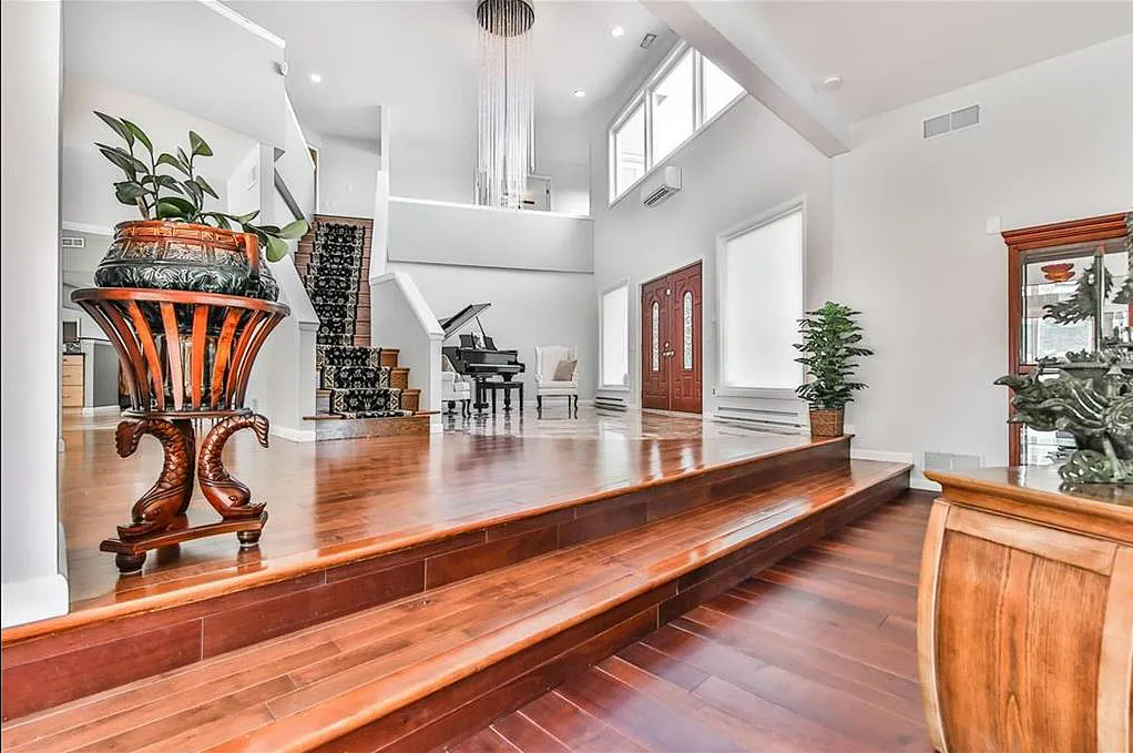 The entrance to this home features a cathedral ceiling and chandelier