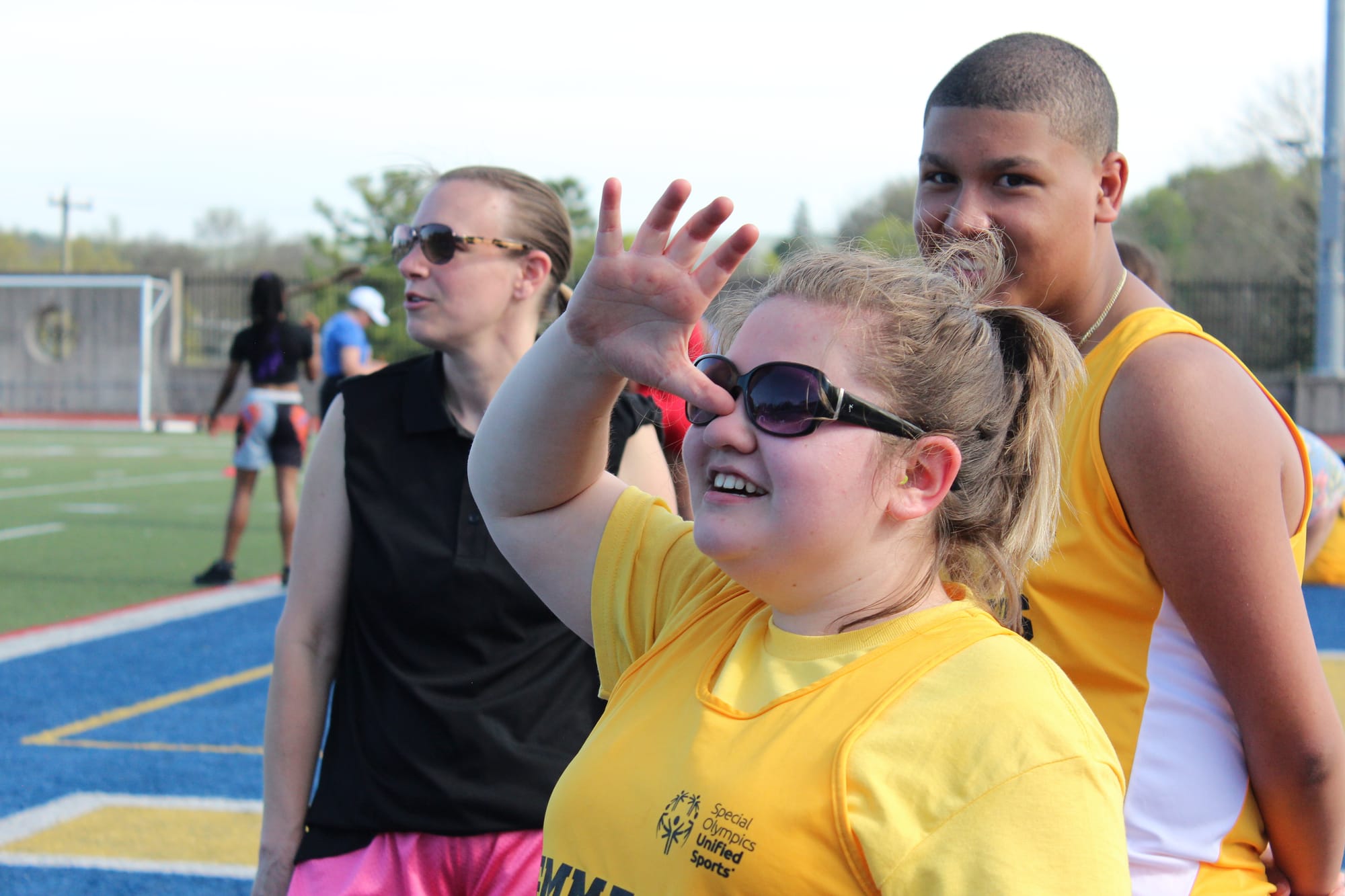 Lia Sampson waves on those cheering her and other athletes on during Friday's meet