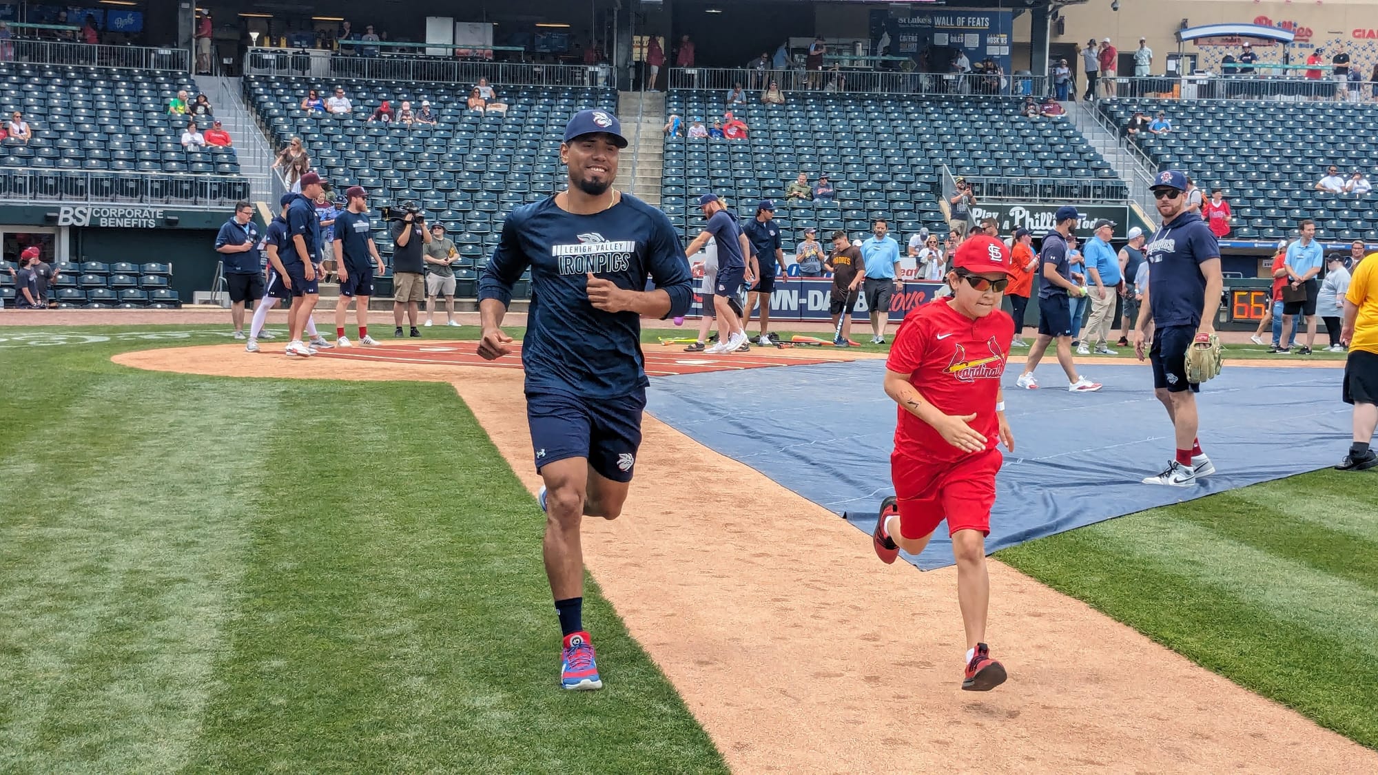 A Miracle League player heads for first base after a hit with a member of the Lehigh Valley IronPigs during an exhibition gam